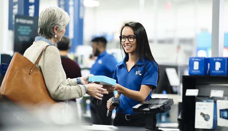 An employee helps a customer check out at a Best Buy store.