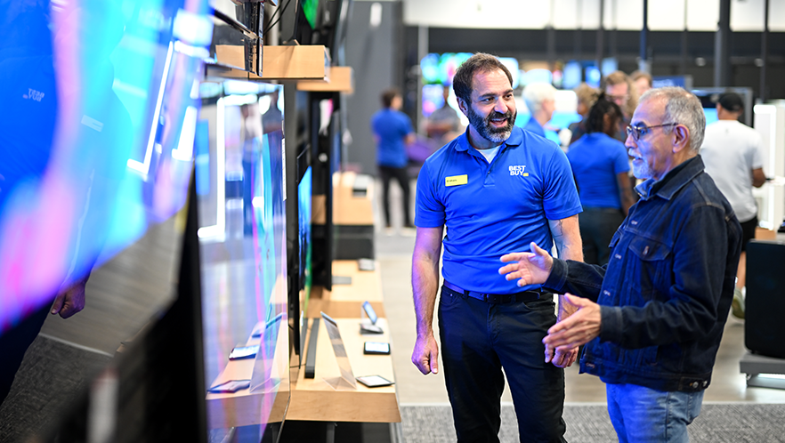 Energy Awareness Month: A Best Buy sales associate looks at TVs with a customer.